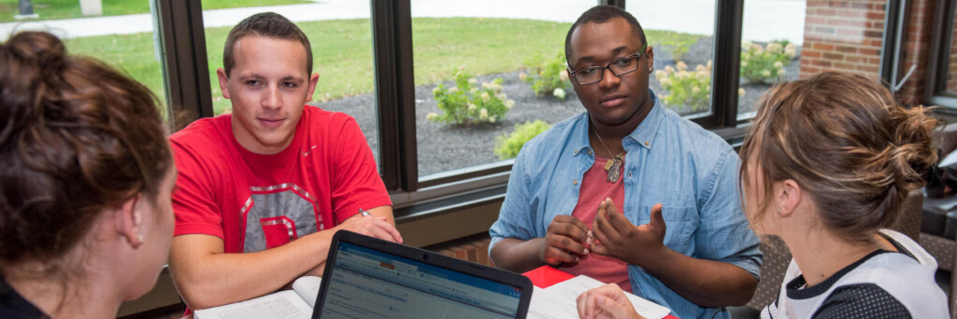 Four Ohio State students participating in a discussion around a table